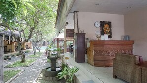Zona de recepción con mostrador, reloj y dispensador de agua.