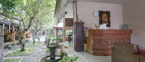 A reception area with a reception desk, a clock, and a water dispenser.