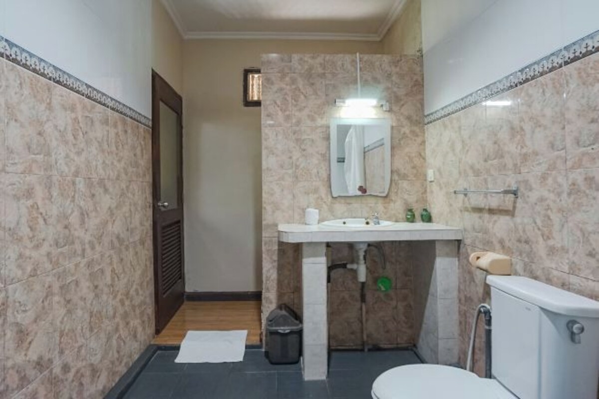 A small bathroom with a toilet, sink, and mirror.