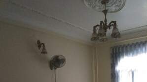 A hotel room with two beds, a ceiling fan, and a window with curtains.