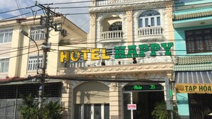 A building with a sign that reads "HOTEL HAPPY".