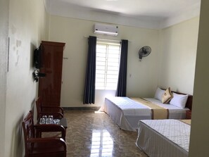 A hotel room with two single beds, a wooden wardrobe, a desk with chairs, and a window with curtains. - Hung Thinh Hotel (Hanoi)