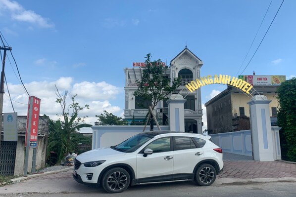 A white SUV parked in front of Hoang Anh Hotel. - Hoang Anh Hotel Ha Nam (Nam Ly)