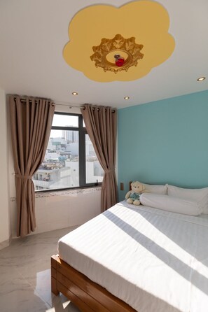 A bedroom with a bed, a window with curtains, a view of buildings, and a decorative ceiling. - 26 Topaz Hotel (Ho Chi Minh City)