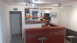 A small, compact room with a kitchenette area, a mirror, and a shelf with various items. - Group Lodging and Event Space: La Ferme d'Odette (Poucharramet)
