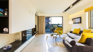 Un salon moderne avec un canapé, une table basse et une vue sur l’extérieur.