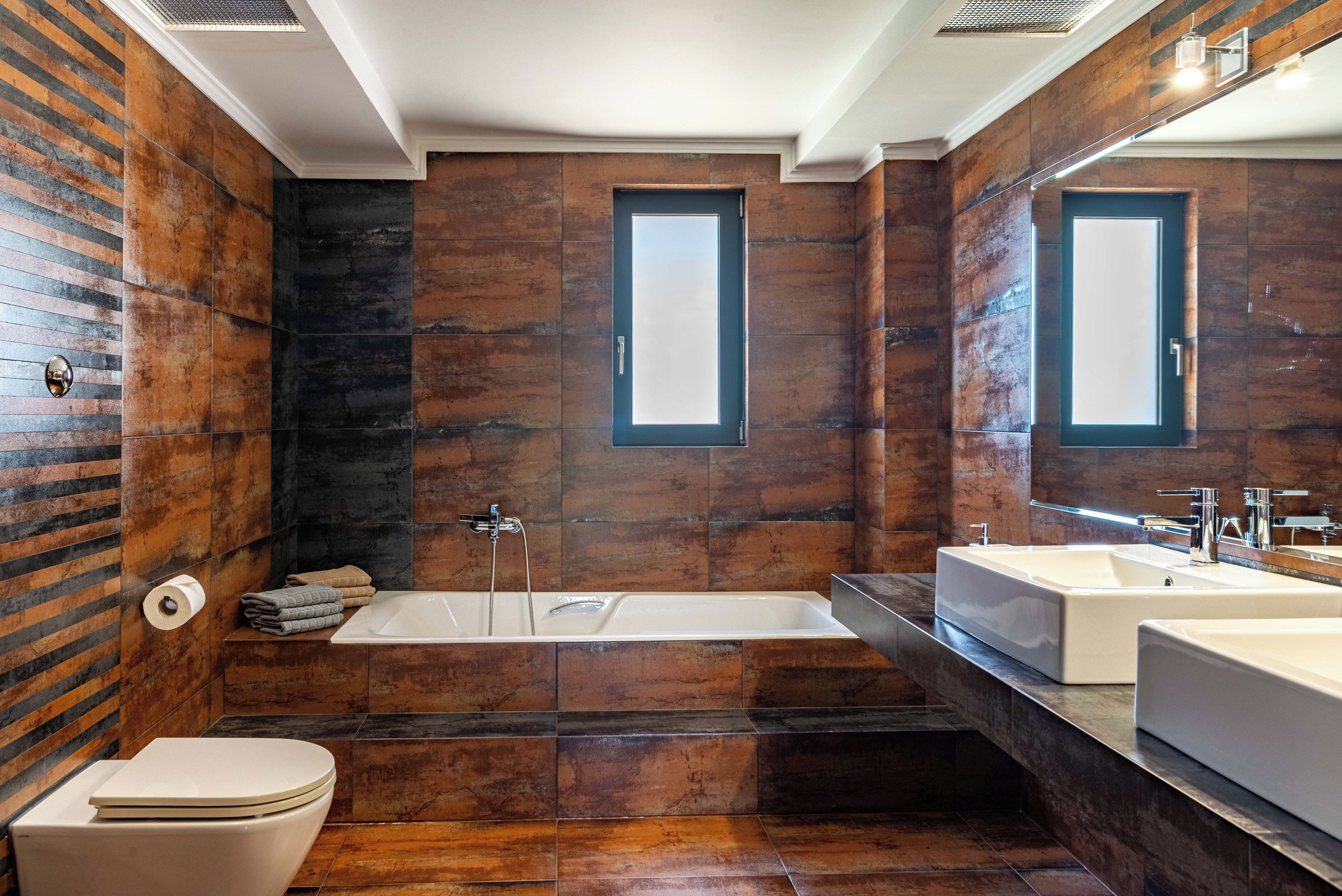 A modern bathroom with a bathtub, a toilet, and a sink.