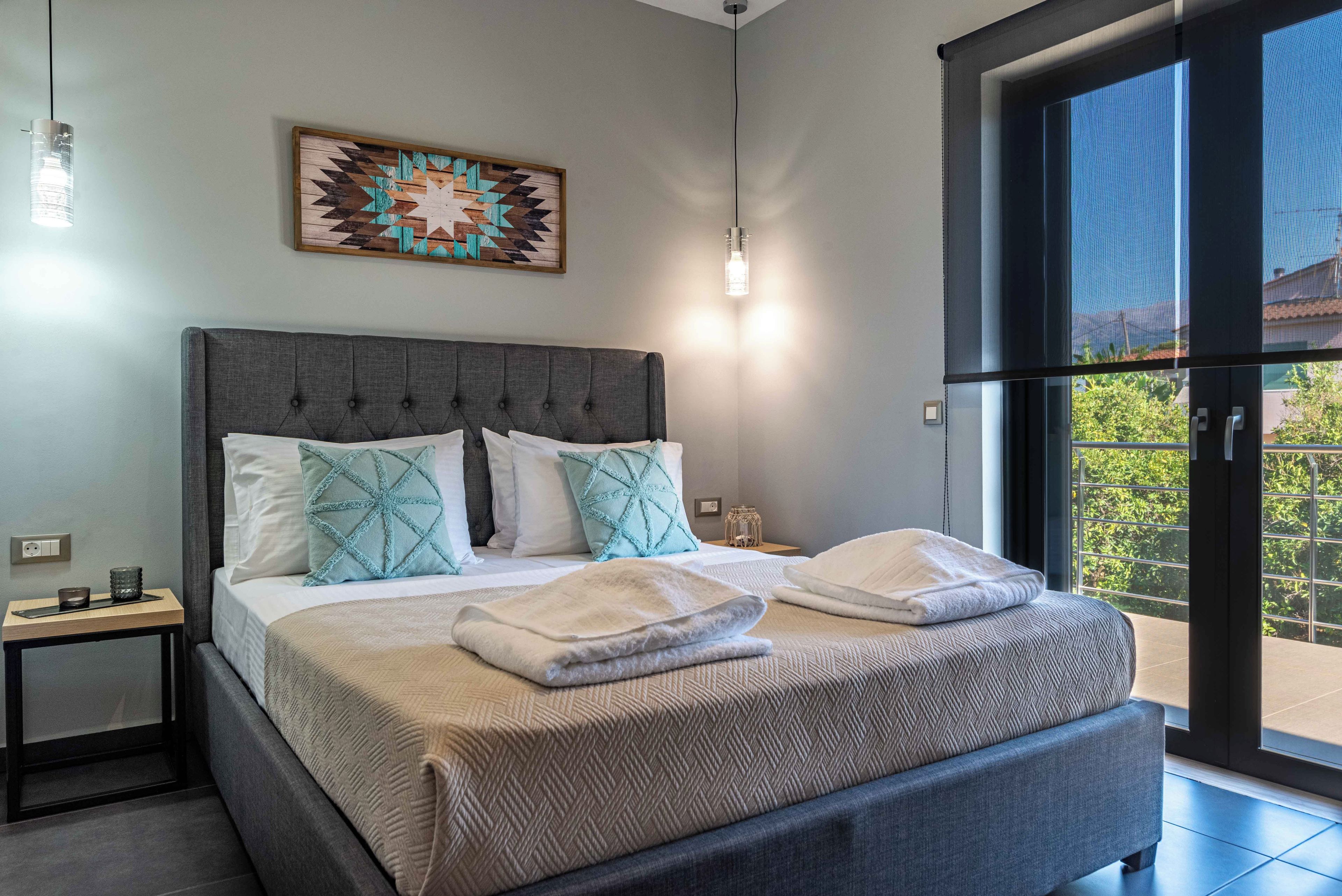 Un dormitorio moderno con una cama grande, un adorno en la pared y vistas a través de una puerta corredera.