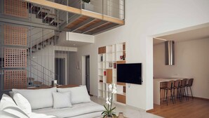 A modern living room with a white sofa, a wooden coffee table with a plant, a TV mounted on the wall, and a staircase with a glass railing. - Omnia Villa l - Heated* pool & stunning Seaview! (Chania)