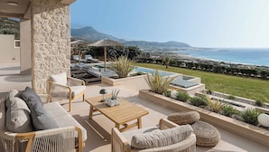 Eine Terrasse mit Gartenmöbeln, einem Pool und Blick auf das Meer und die Berge.
