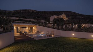 Una casa moderna con piscina, mobiliario exterior y vistas del paisaje circundante.