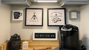 A kitchen with a microwave, coffee maker, and framed motivational quotes on the wall. - Perfectly Located Fully Remodeled Desert Casita (Bermuda Dunes)