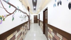 A hallway with tiled floors and walls decorated with floral patterns. - Hotel Eurasia Mohali Airport (Mohali)