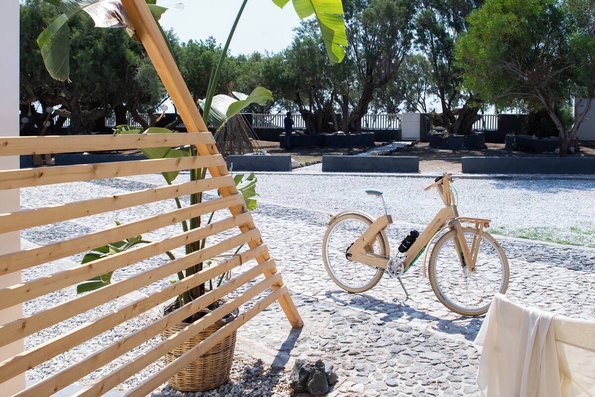 A wooden bench, a bicycle, and a table with a cloth.