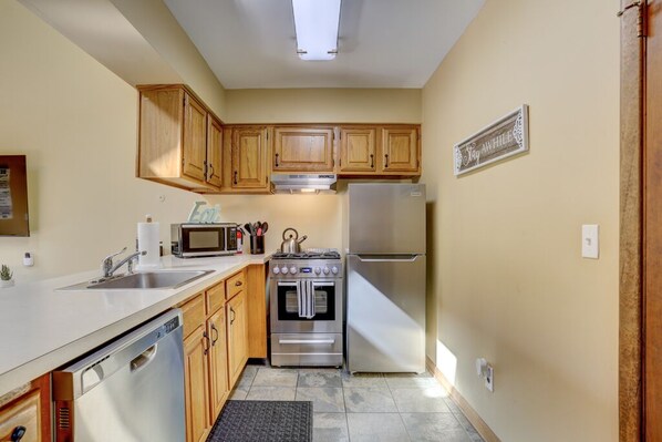 A compact kitchen with wooden cabinets, a stainless steel refrigerator, a microwave, an oven, and a dishwasher. - Mountain Creek Resort Condo - Golf, Hike, Legoland, Bike, NYC 1 Hour (Vernon Township)