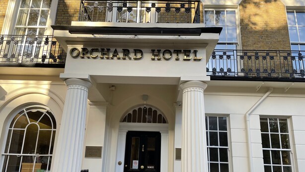L’extérieur de l’hôtel Orchard se distingue par sa façade classique, ses grandes fenêtres et son entrée imposante.