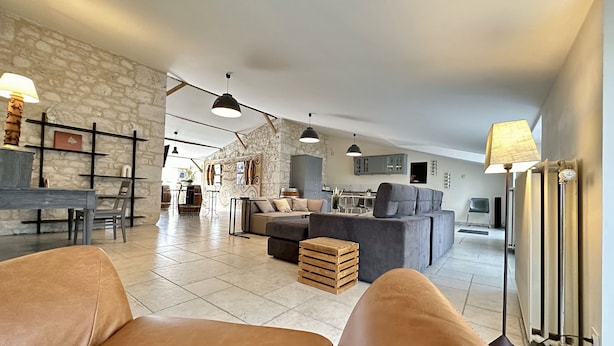 A spacious living area with a sofa, a coffee table, and a dining area with a table and chairs.