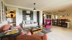A living room with a sofa, armchairs, a coffee table, and a dining area with a table and chairs. - Le Belvue, a relaxing stay with a view of the Pyrenees mountain range  (ESTIALESCQ)