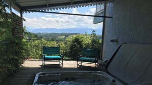A hot tub on a wooden deck with a view of mountains. - Le Belvue, a relaxing stay with a view of the Pyrenees mountain range  (ESTIALESCQ)