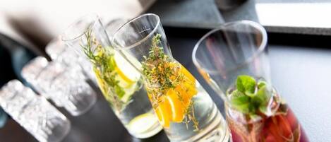 Three glasses of water with lemon slices and herbs.