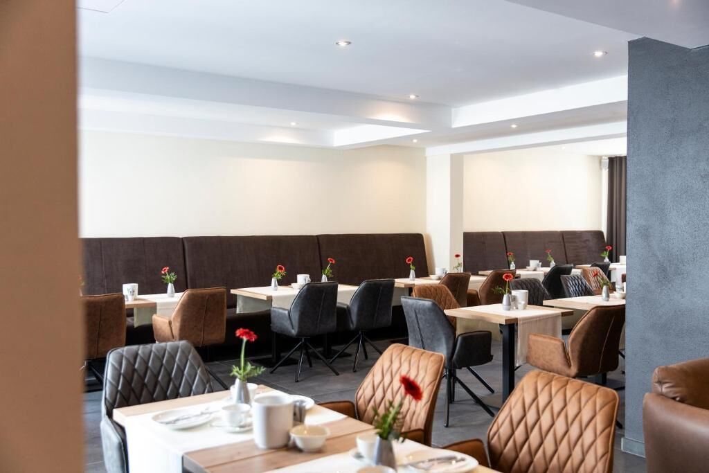 Un restaurante moderno con asientos tipo cabina y mesas individuales, con un diseño contemporáneo y limpio.