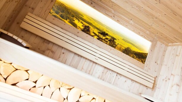 Un interior de madera con un amplio ventanal que da a un paisaje.