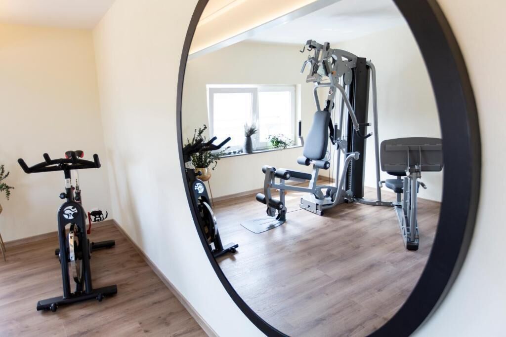 A home gym with exercise equipment, a window, and a plant.