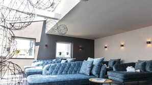 Una sala de estar moderna con un sofá modular, una mesa de centro redonda y una pared de acento oscura.
