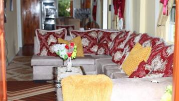 A living room with a sofa set, a coffee table, and a yellow throw blanket.