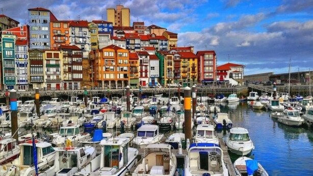 A marina filled with boats and colorful buildings in the background. - URDAIHOME APARTMENT (Gernika-Lumo)