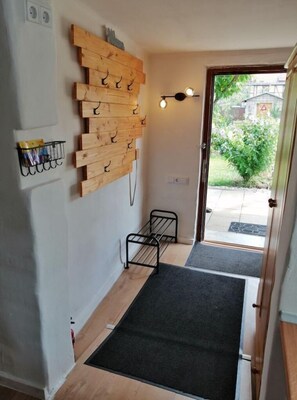 Simple, functional room with a wooden rack and storage shelf, perfect for hanging keys and storing essentials.