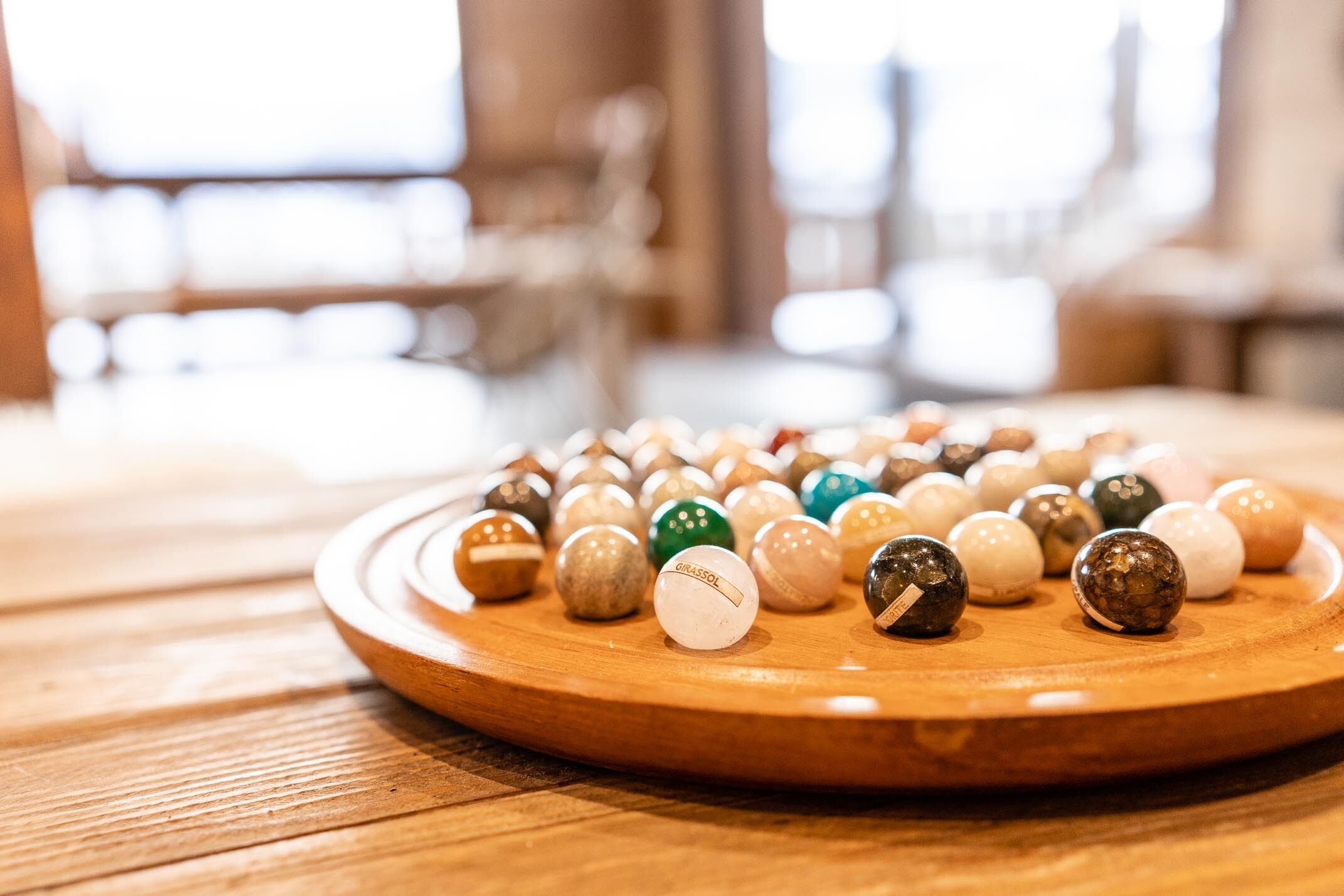Une table en bois sur laquelle sont disposées des balles de golf en cercle.