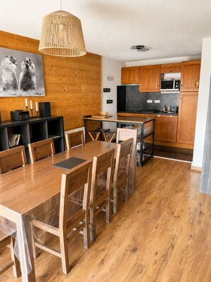 A modern kitchen with wooden cabinets, a black countertop, and a microwave.
