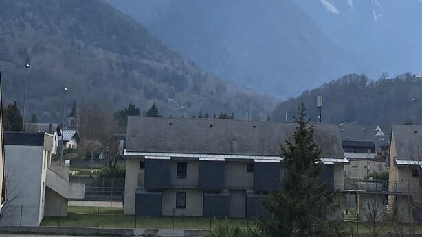 Ein Gebirge mit schneebedeckten Gipfeln unter einem teils bewölkten Himmel.