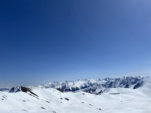 Eine verschneite Berglandschaft mit wolkenlosem, blauem Himmel.