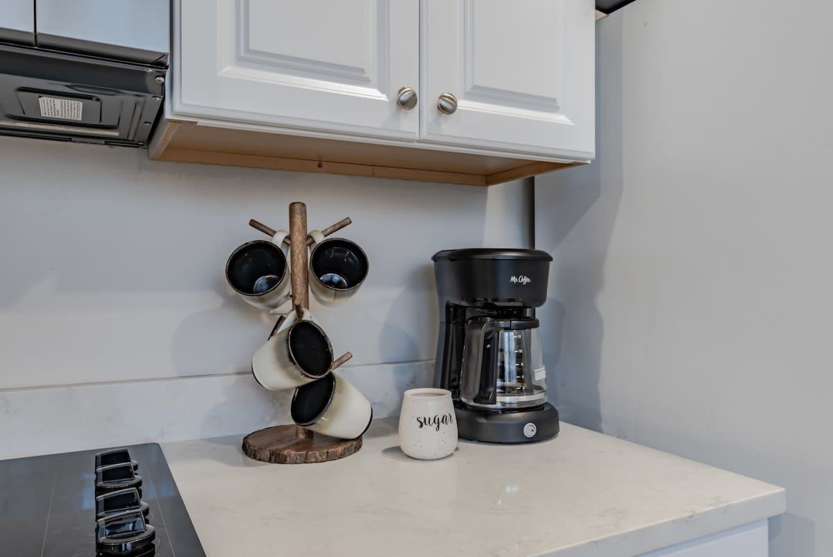 Un comptoir de cuisine avec une machine à café, une tasse et un porte-tasses.