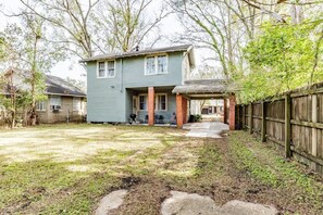 A two-story house with a front porch, a covered entryway, and a fenced backyard.