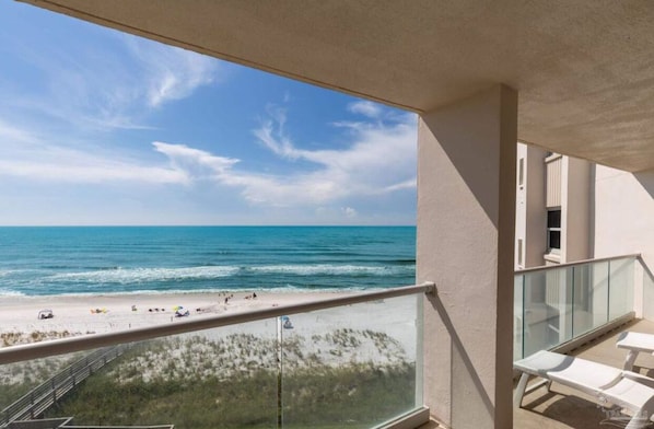 Un balcon avec vue sur la plage et l’océan.