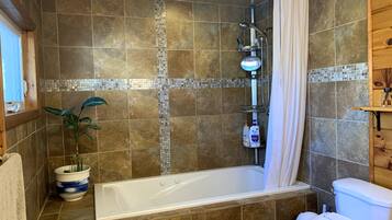 Een bad/douchecombinatie, een bubbelbad, een haardroger, een bidet