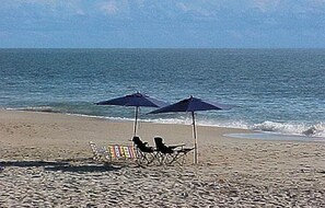 A beach with two umbrellas and beach chairs. - Ocean View * 5BR Luxury Single Family House! (Ocean View)