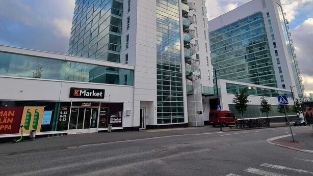 Ein modernes Gebäude mit Glasfassade und einem KMarket Geschäft im Erdgeschoss.