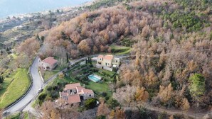 A residential area with two houses, a winding road, and a pool. - Two-room apartment in the countryside a stone's throw from the sea (Calice Ligure)