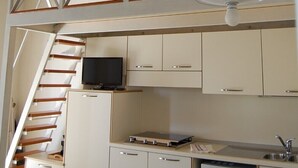 Una cucina funzionale con forno a microonde, un piccolo frigorifero e un tavolo da pranzo in legno.