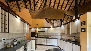 Keittiössä on keskellä sijaitseva saareke, valkoiset kaapit ja laatoitettu seinäosa työtason yläpuolella.