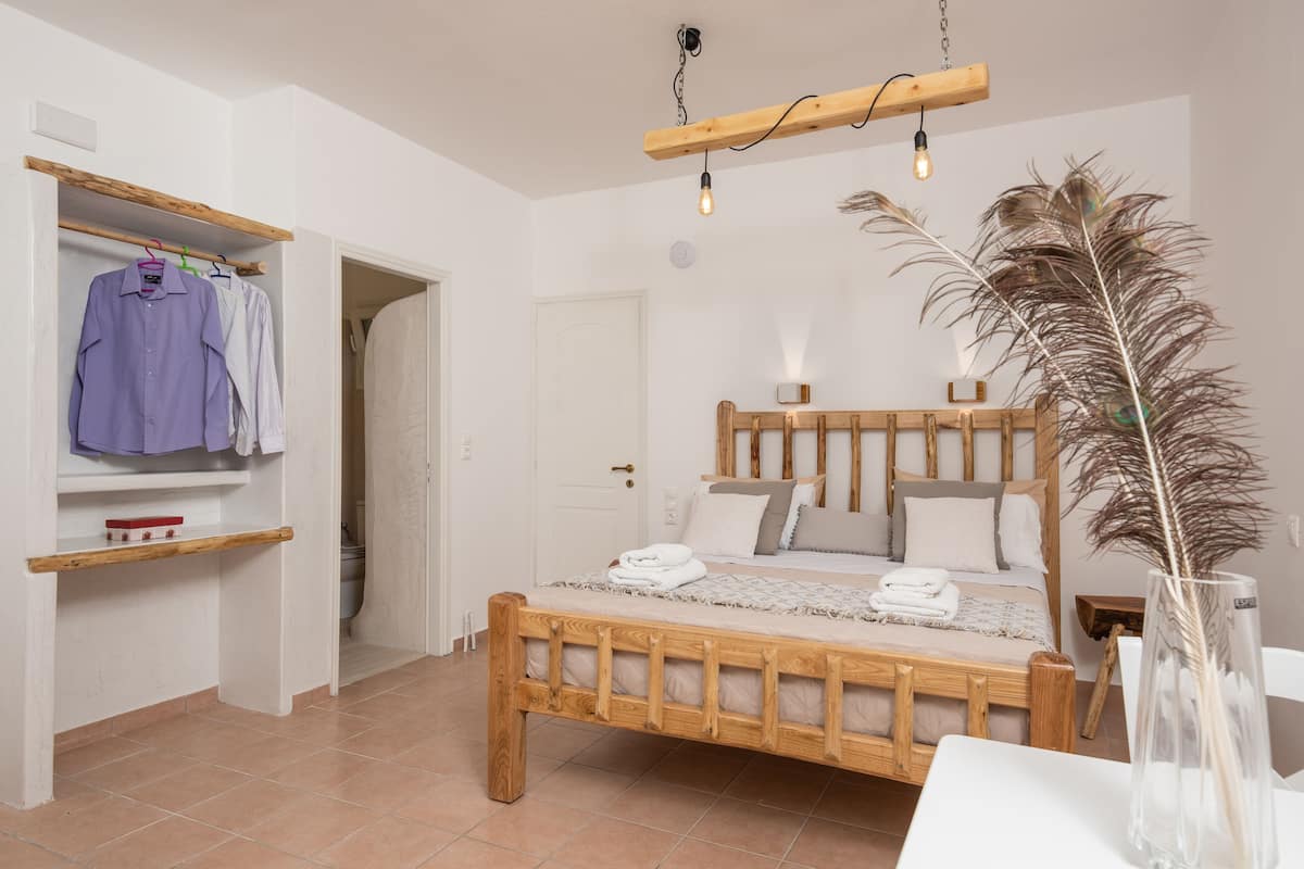 Ein Schlafzimmer mit einem hölzernen Bett, einem Kleiderschrank und einer Pendelleuchte.
