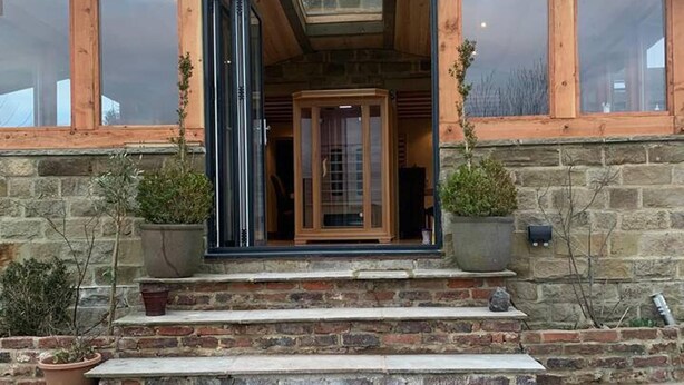 A stone building with a wooden front, large windows, and a door. - Meagill Farmhouse, hot Tub, bbq hut (Otley)