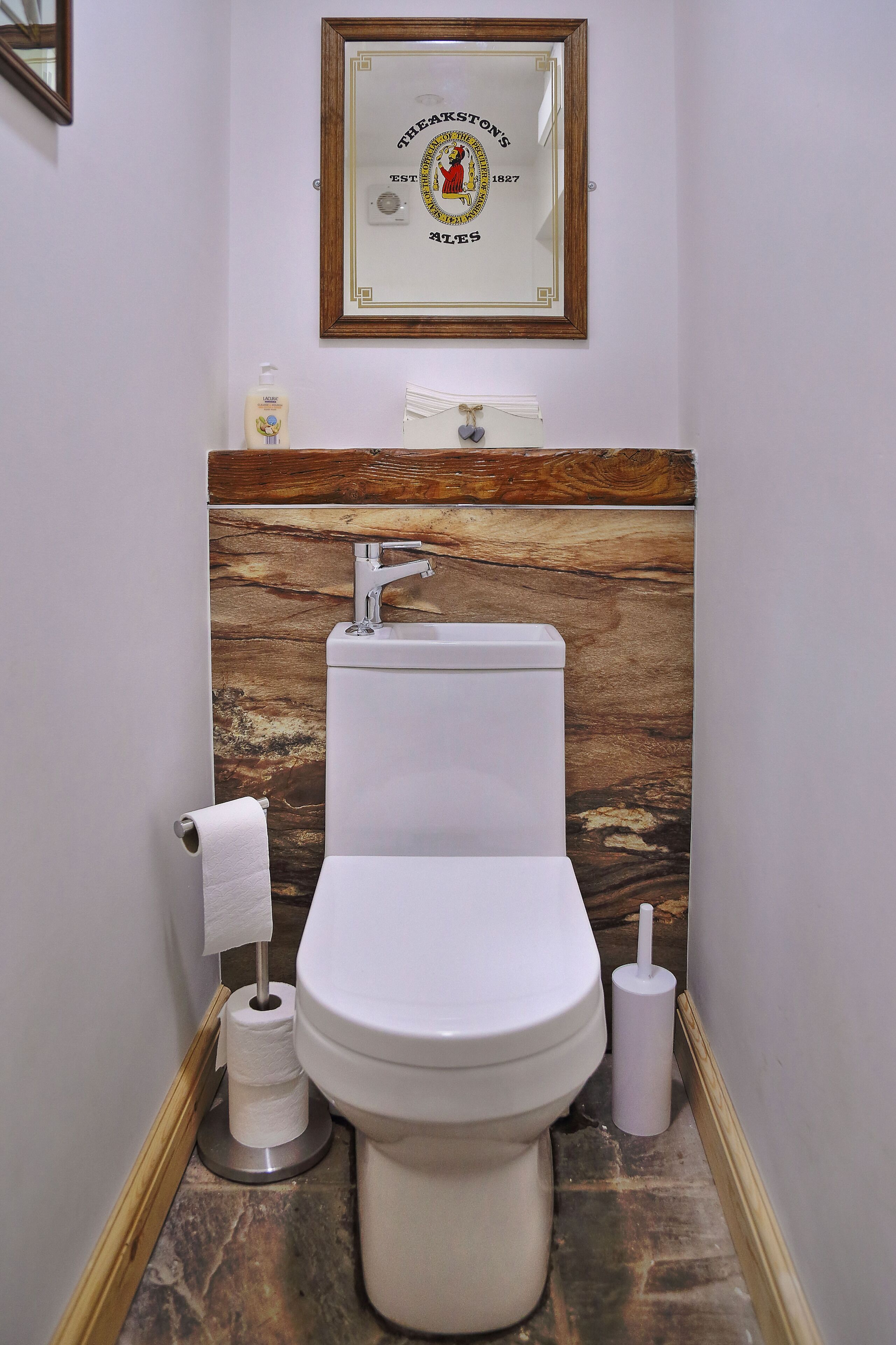 A bathroom with a toilet, sink, and a framed certificate on the wall.