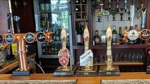 Un bar con múltiples grifos de cerveza, incluyendo marcas como Guinness y John Smith's.