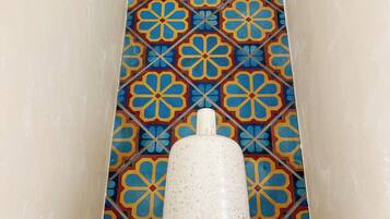 A bathtub with a geometric tile pattern and a white object in the center.