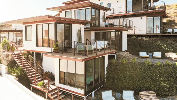 A modern multi-story house with a balcony, outdoor seating, and a staircase. - Native Residence (Playas de Rosarito)